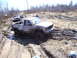 1996 Ford Bronco - Several trucks navigate a challenging muddy off-road course on a sunny day.