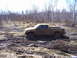 1996 Ford Bronco - Pickup truck is stuck in the mud, being pulled by a rope.
