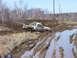 1996 Ford Bronco - A pickup truck is stuck in a muddy trail with water and ruts.