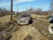 1996 Ford Bronco - Multiple trucks navigate a muddy off-road course, with one red pickup truck deeply stuck in the mire.