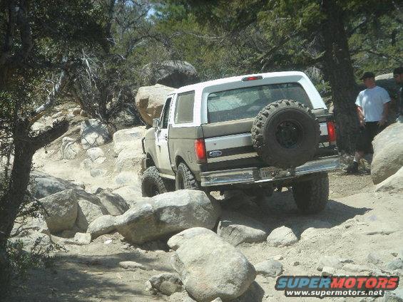 Ford Bronco navigating a rocky trail, spare tire mounted on the back