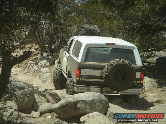 1994 Ford Bronco rear view, white and brown, off-roading on rocky trail