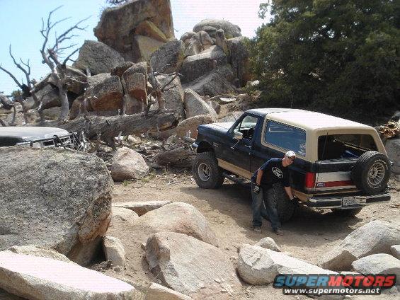 Ford Bronco on rocky trail with another vehicle partially visible on left