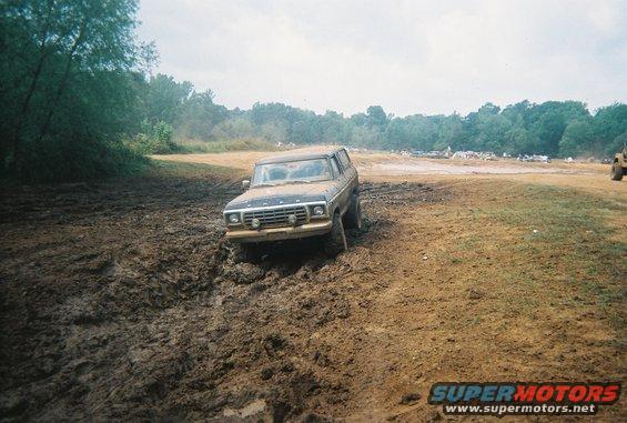 1978 Ford Bronco struggling through deep mud on an off-road course