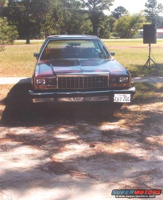 Front view of a dark red Ford Crown Victoria with a chrome grille and Texas license plate C63-ZGC