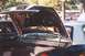 2002 Ford Crown Victoria - The trunk of a car is open, revealing the spare tire and storage area, with other vehicles in the background.