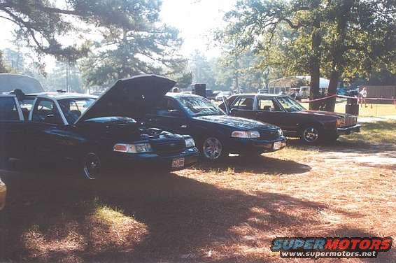 Dark 2002 Ford Crown Victoria with hood open, parked outdoors