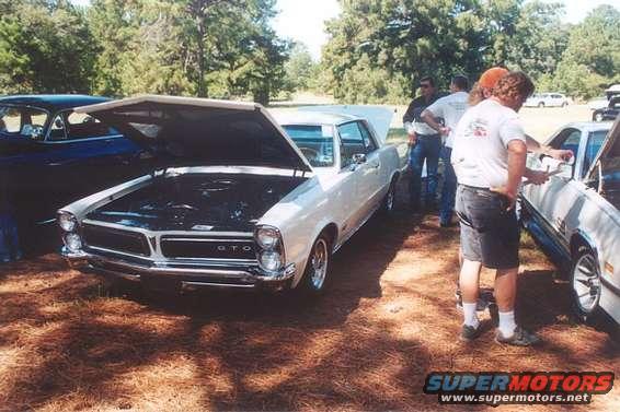1965 Pontiac GTO with hood open, parked next to a blue car
