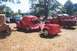 2002 Ford Crown Victoria - Several vintage vehicles, including a red coupe and trucks, are parked on a grassy field.