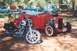 2002 Ford Crown Victoria - A motorcycle and a red hot rod car are parked outdoors with other vehicles in the background.