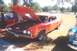 2002 Ford Crown Victoria - Orange classic car with hood open, parked on grass next to a blue car.