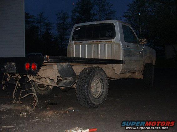 Silver flatbed truck, rear view, with exposed wiring and dual taillights