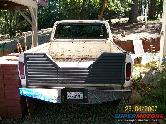 Rear view of a white pickup truck with a custom bumper and California license plate 3NKW194