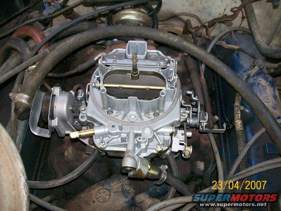 Close-up of a Motorcraft carburetor in an engine bay with hoses and wiring