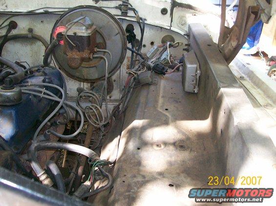 Engine bay with brake booster, master cylinder, and wiring visible