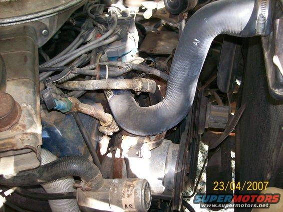 Close-up of engine bay showing hoses, belts, and engine components. Date stamp reads 23/04/2007
