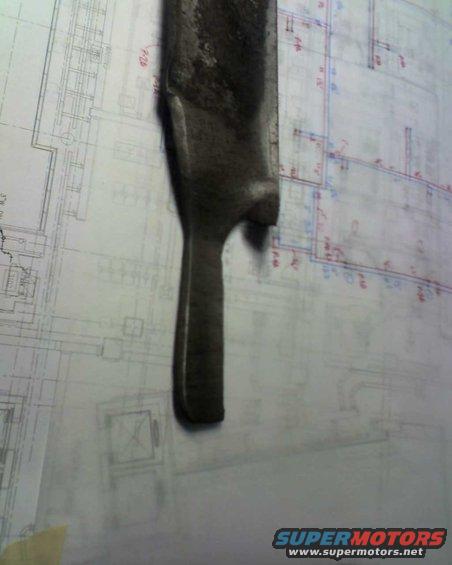 Metal part resting on architectural blueprints