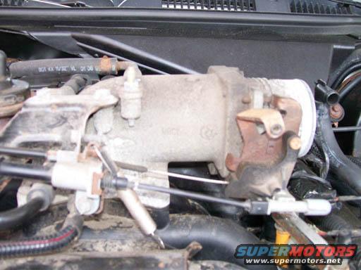 Close-up of a throttle body assembly with cables attached
