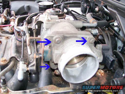 Throttle body assembly with blue arrows pointing to mounting bolts