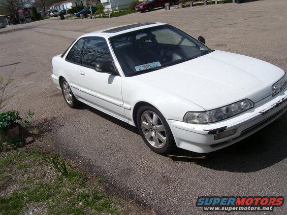 White coupe with sunroof and aftermarket wheels. License plate reads D PF015