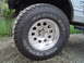 1989 Ford Bronco - This photo shows a close-up of an off-road tire and wheel assembly, with visible text indicating its type and brand.