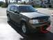 1998 Ford Crown Victoria - Green Ford Explorer SUV parked on asphalt, front view. Red circle highlights part of the front bumper.