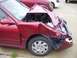 1996 Ford F-350 - A red car sustained heavy front-end damage, with its hood crumpled and windshield shattered.