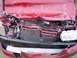 1996 Ford F-350 - Front end of a red car severely damaged in a collision, with the hood and bumper crumpled.
