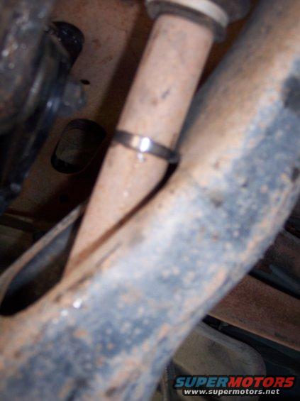 Close-up of a clamp on a pipe under a vehicle