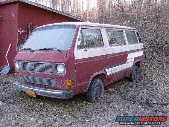 Volkswagen Vanagon parked in front of a red shed, flat tires