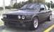 1989 BMW 3 Series - Front 3/4 view of a dark gray 1989 BMW 3 Series coupe with aftermarket wheels.