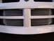 1996 Ford Probe - Close-up of a white car's front grille, revealing two prominent intercoolers behind the horizontal bars.