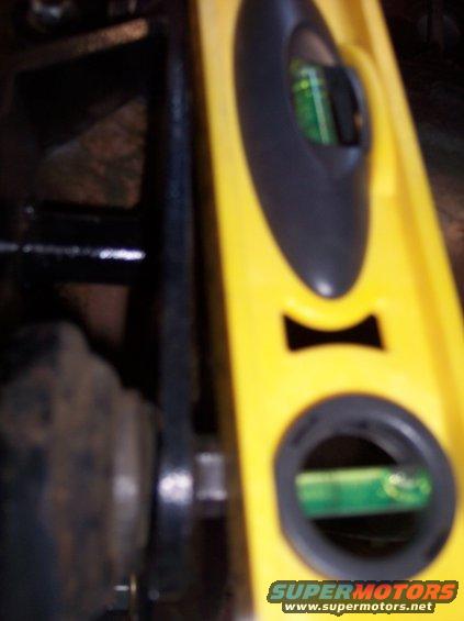 Yellow level tool measuring a vehicle part