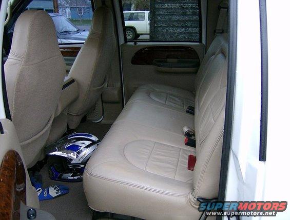 Interior shot of a truck's back seat with a helmet and shoes on the floor