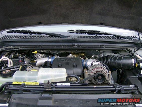 2000 Ford F-250 engine bay with a large black air intake hose, alternator, and coolant reservoir