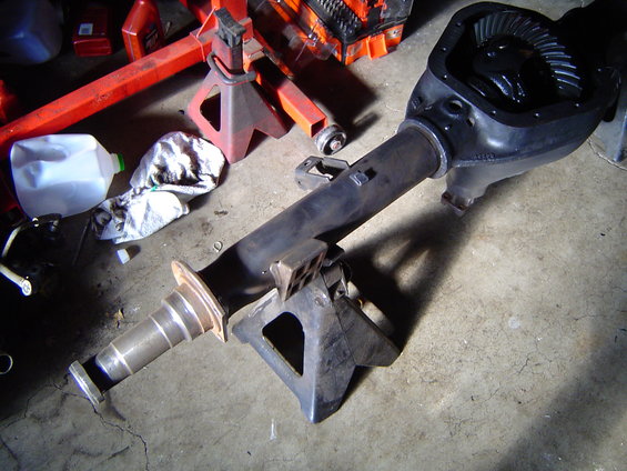 Differential axle assembly on jack stands, with gears visible inside the housing