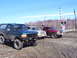 1996 Ford Bronco - Three SUVs and a pickup truck are parked near a railroad crossing on a dirt road.