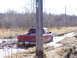 1996 Ford Bronco - A red pickup truck navigates a challenging muddy terrain with a visible license plate.