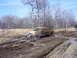 1996 Ford Bronco - A yellow pickup truck navigates a muddy off-road trail with another vehicle visible in the background.
