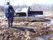 1996 Ford Bronco - Pickup truck stuck in mud with a person standing next to it.