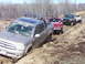 1996 Ford Bronco - Several off-road vehicles are stuck in thick mud on a trail.