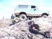 1996 Ford Bronco - A 1996 Ford Bronco navigates a challenging rocky trail, with another vehicle partially visible.