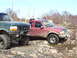 1996 Ford Bronco - Mud-splattered 1995 Ford F-150 is seen from the front, parked off-road with other vehicles.