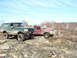 1996 Ford Bronco - Two 4x4 vehicles, a green Bronco and a red pickup, navigate a rough, rocky landscape under a clear sky.