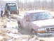 1996 Ford Bronco - Two vehicles, a red Ford Ranger and a green Ford Bronco, are stuck in the mud off-road.