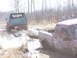 1996 Ford Bronco - A green 1996 Ford Bronco is being pulled from a muddy ditch by a red pickup truck.