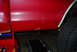 1979 Ford F-150 - Rust is visible on the lower body panel of a red vehicle, with another vehicle in the foreground.