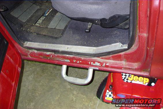 Red truck interior showing door sill, floor mat with 'Ford' text, and a step