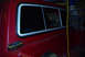 1979 Ford F-150 - Close-up of a red pickup truck's side, focusing on the window and fuel door area.