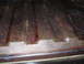 1973 Ford Ranchero - The ribbed surface of a truck bed floor shows significant rust and some white residue along the edge.